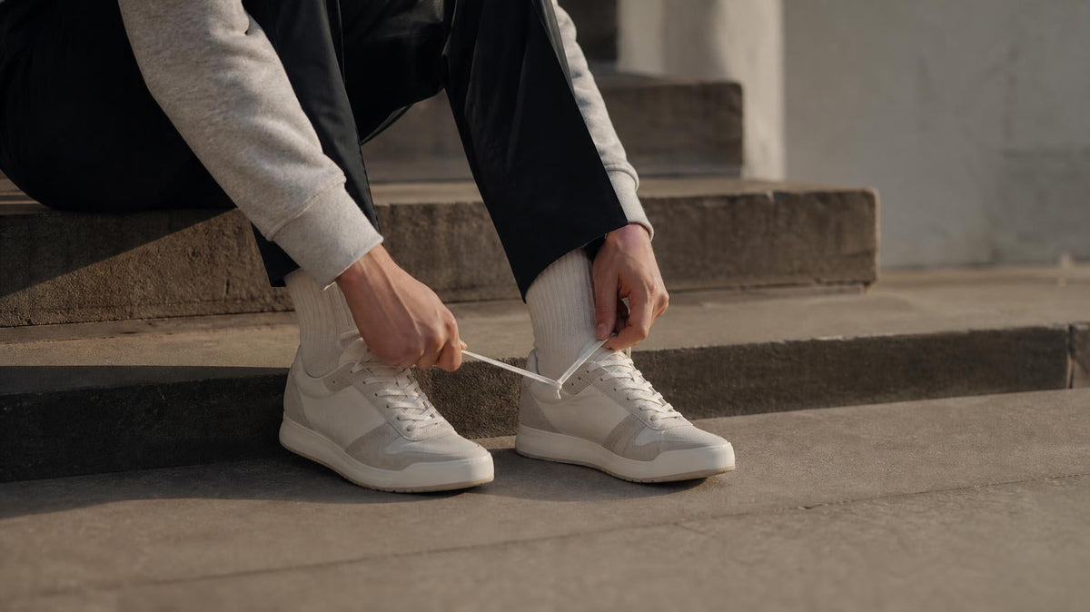 Sneakers med snørebånd sat i et lyst, skandinavisk miljø