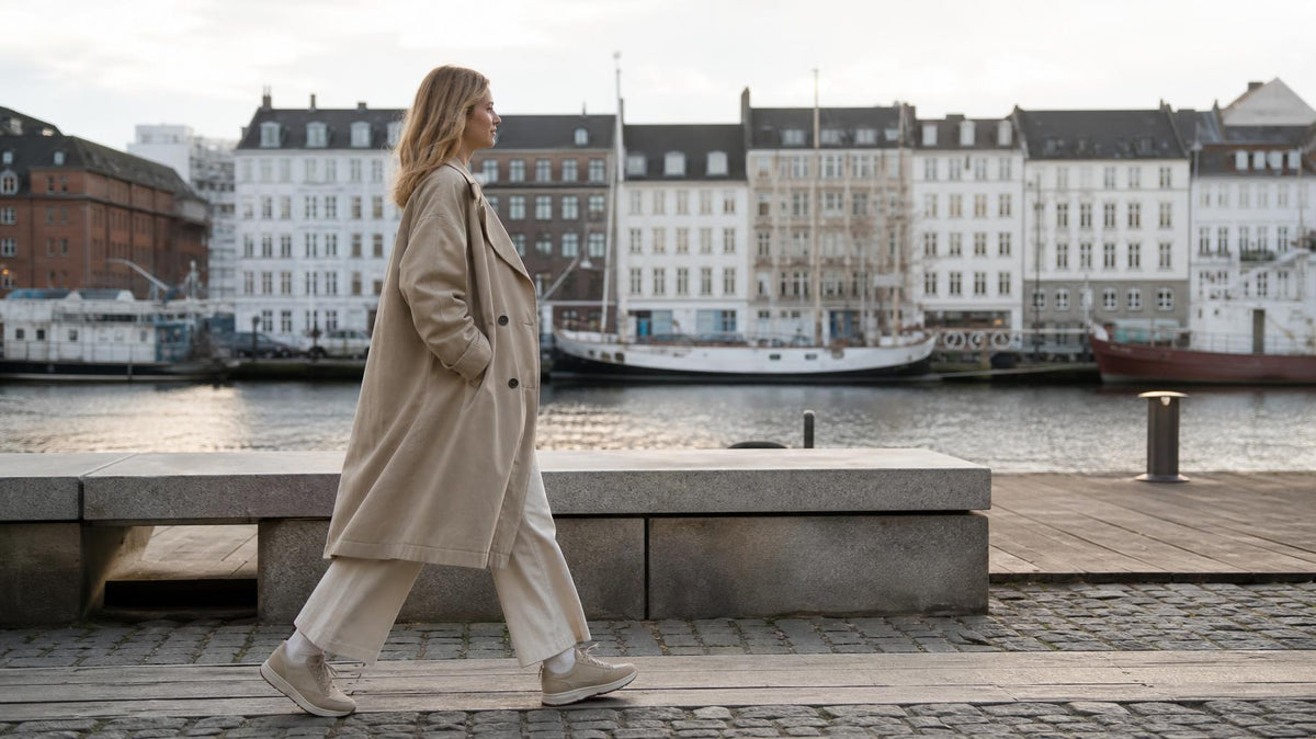 Person går afslappet gennem byen i komfortable sneakers i naturligt lys